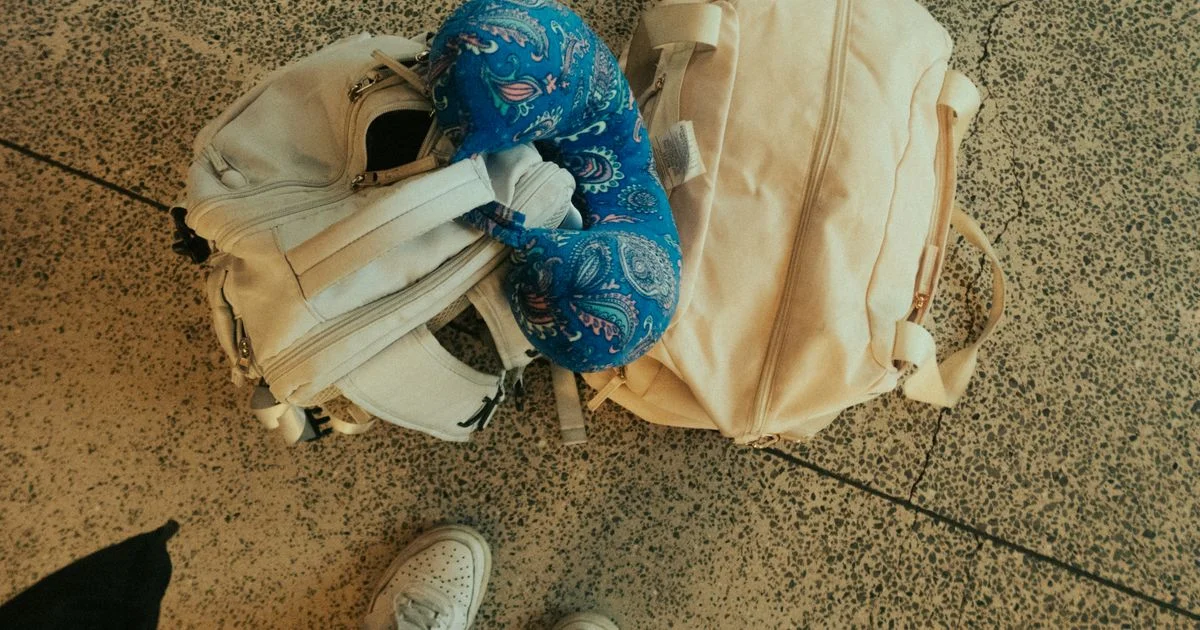 A travel neck pillow with speaker sitting on top of packed luggage at the airport