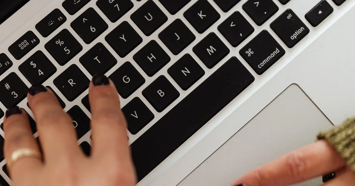 Person typing on a laptop keyboard while using a writing app