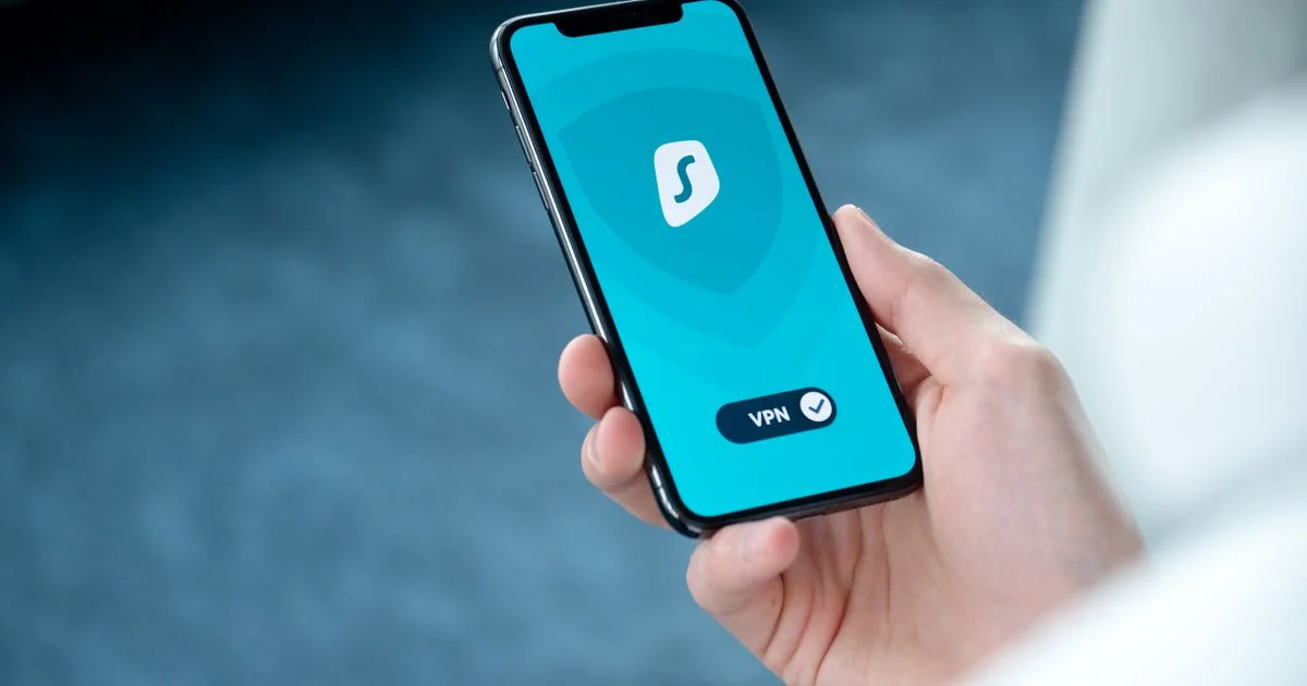 Hand holding an iPhone showing a VPN app connected screen