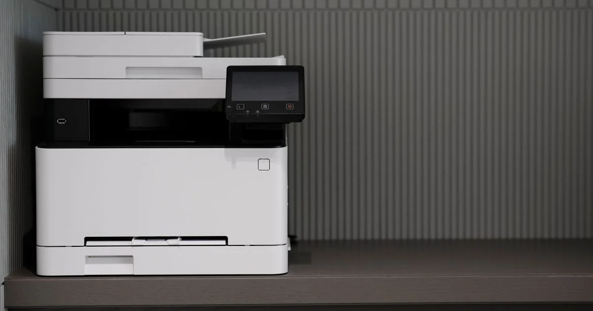 Compact laser all-in-one printer sitting on a home office shelf, an example of a budget printer for home office use