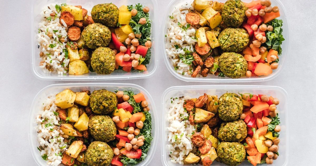 Four prepared meal containers of rice, roasted vegetables, chickpeas and greens, the food behind is a diabetic diet foods plan worth it