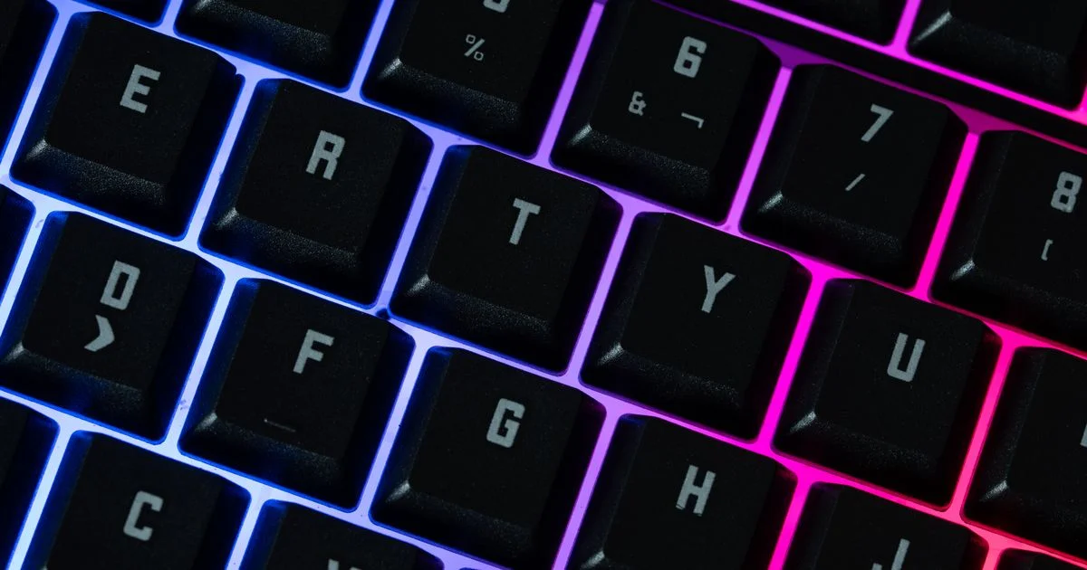 Backlit black keycaps glowing blue and pink, the question behind is RGB keyboard worth it for the money
