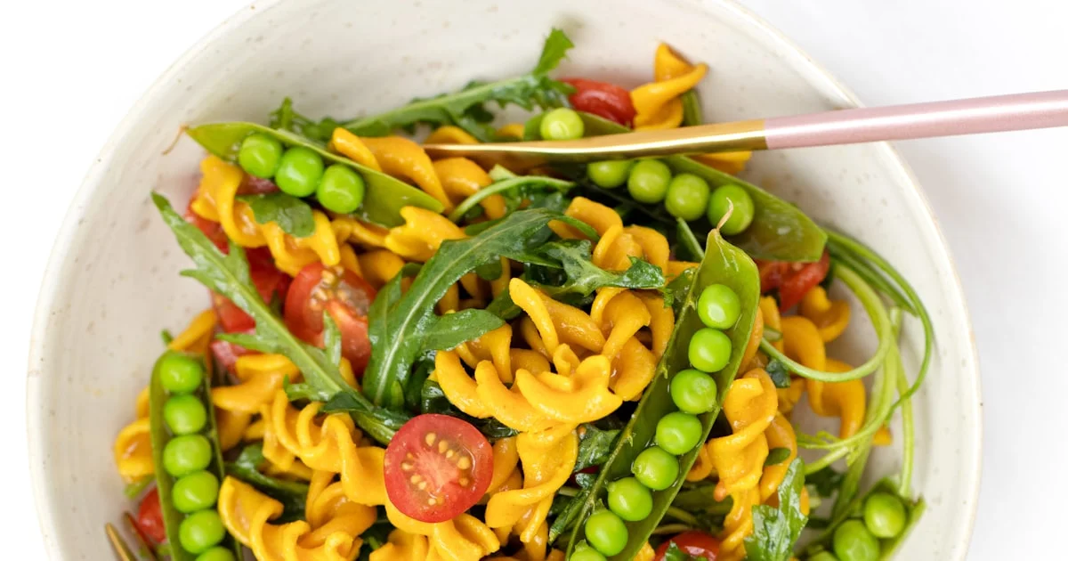 Bowl of plant based pasta salad with peas, tomatoes and arugula for beginners starting a plant based diet