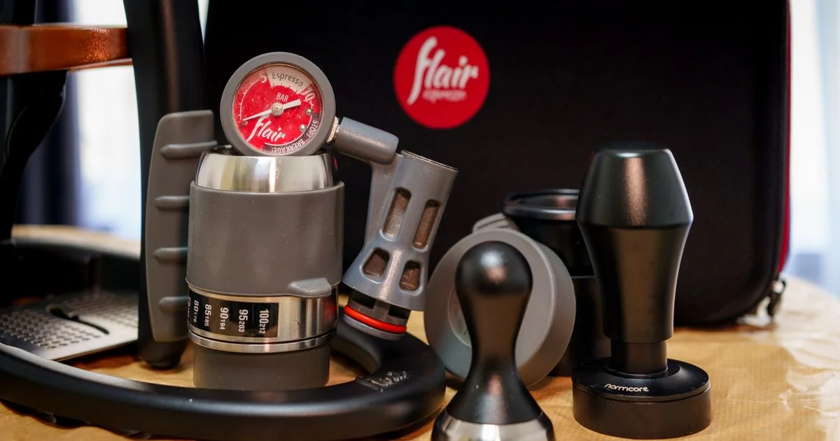 Manual portable espresso maker with pressure gauge, tampers, and travel case