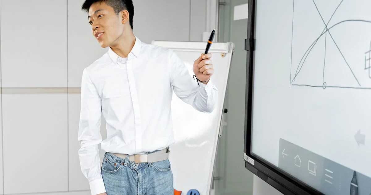 A flip chart beside a large interactive display showing an on-screen toolbar, the comparison behind a smart board price