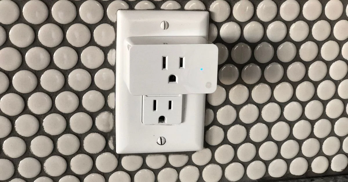 Smart plug plugged into a wall outlet with blue LED indicator